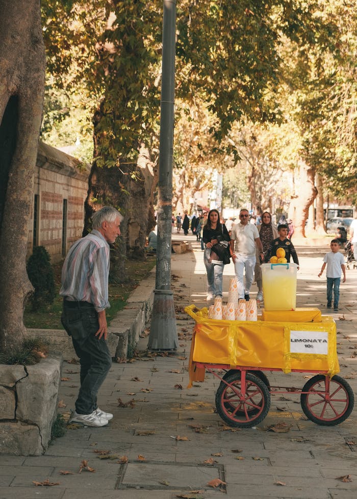 Home A bustling street in Istanbul with a lemonade stand and pedestrians enjoying a sunny day.